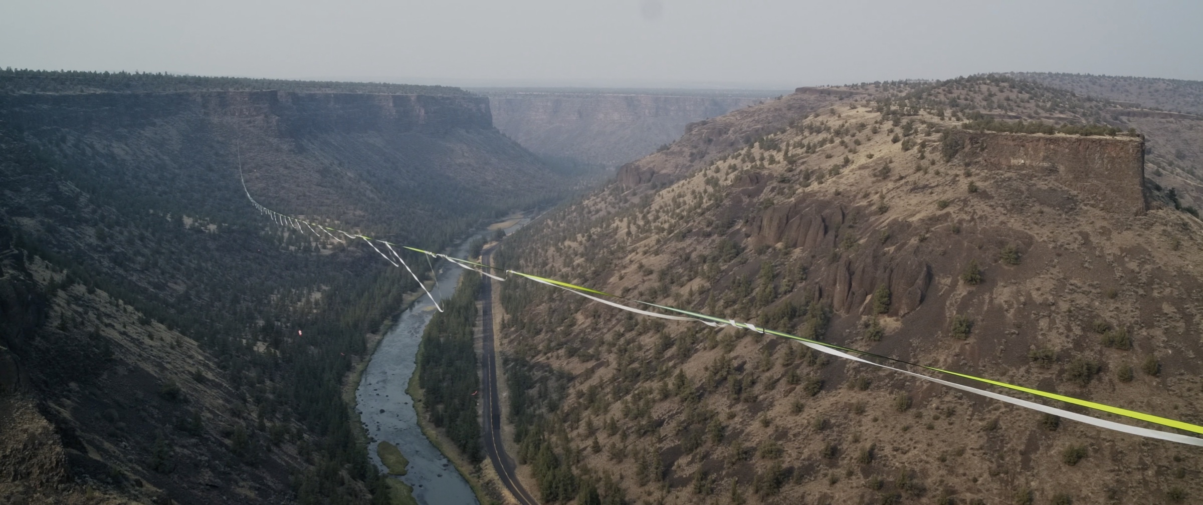 A slackliner far out on a highline above the Crooked River canyon.